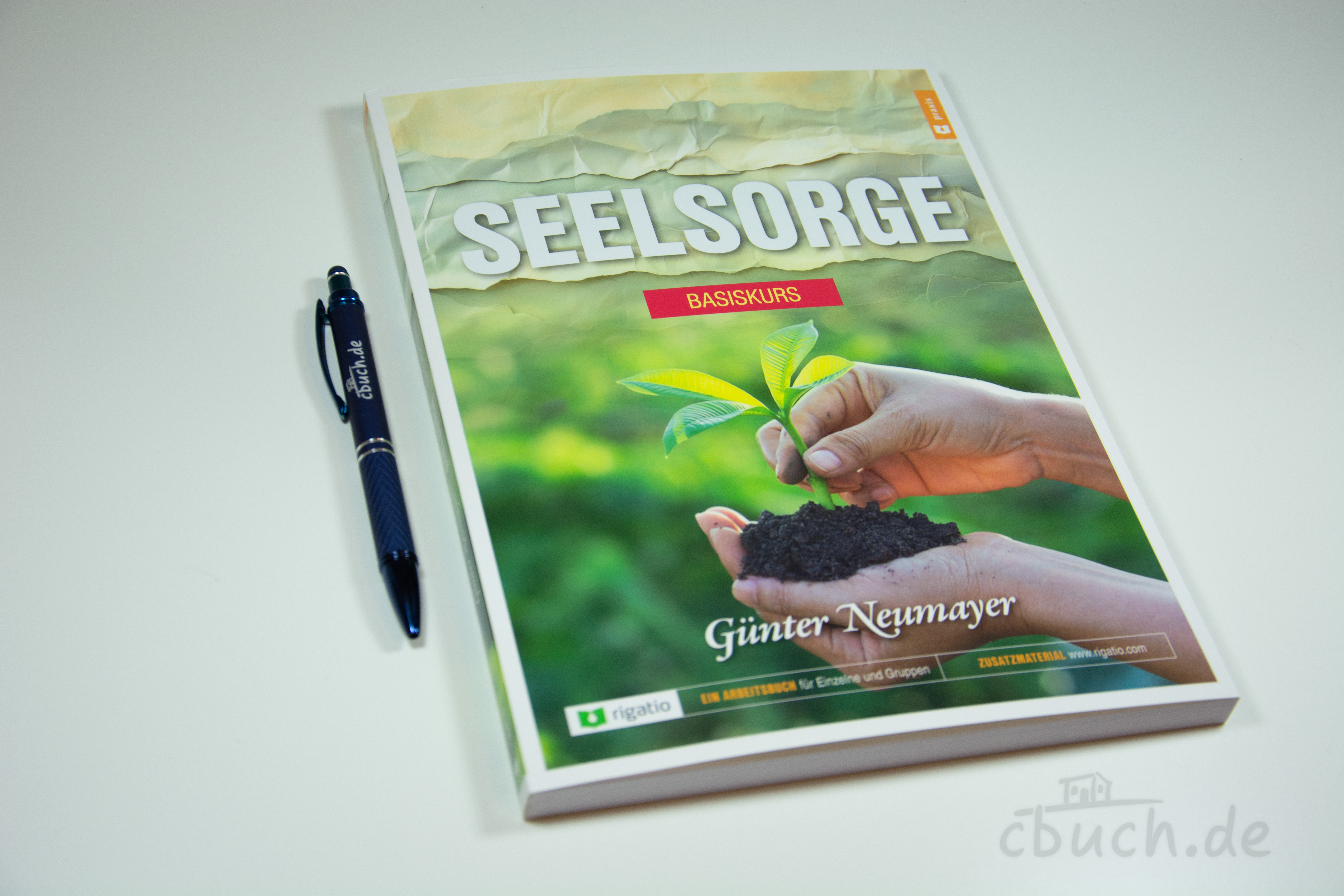 Buch Seelsorge Basiskurs mit Pflanze in Händen und Stift