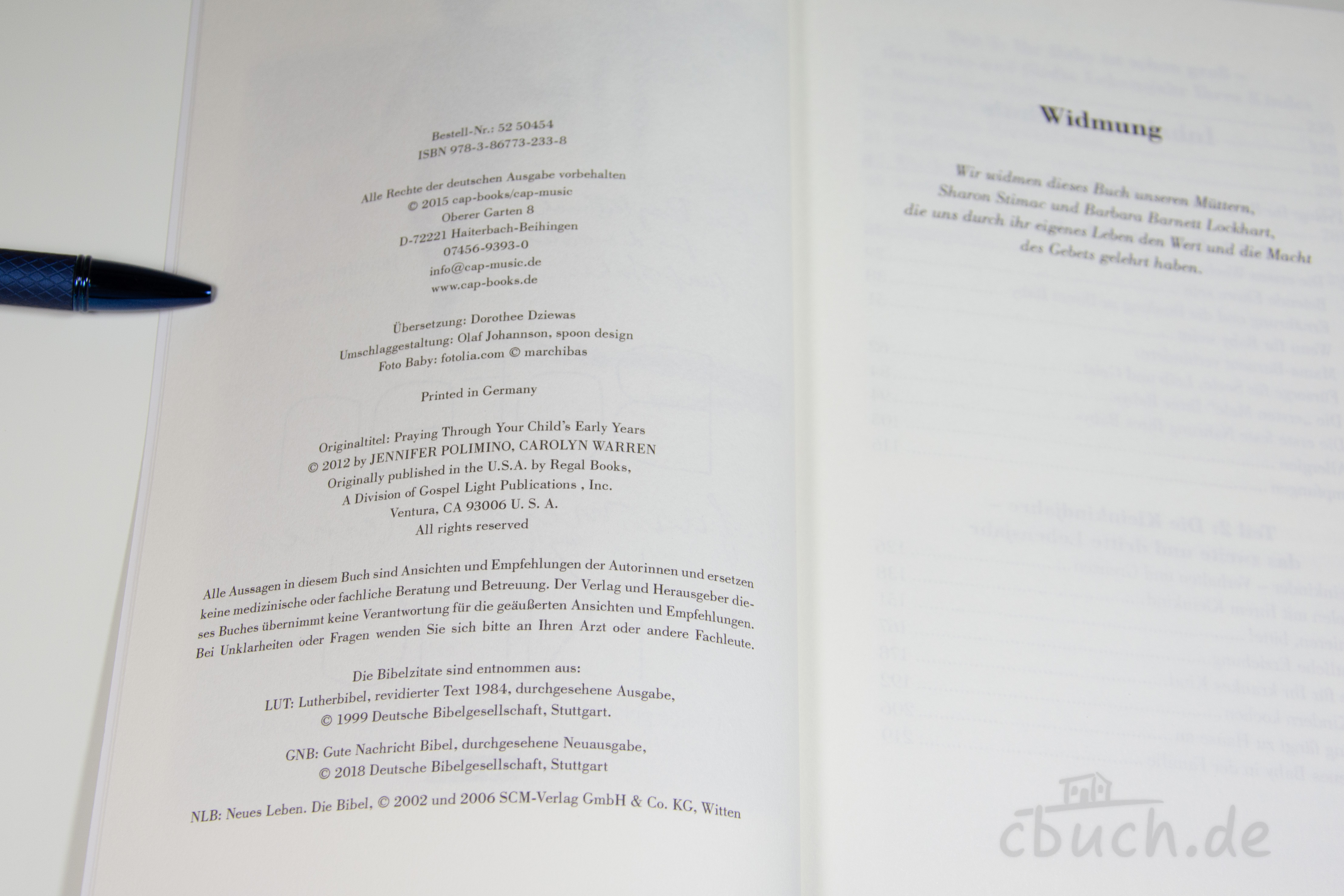 Offenes Buch zeigt Impressum und Widmungsseite mit Stift