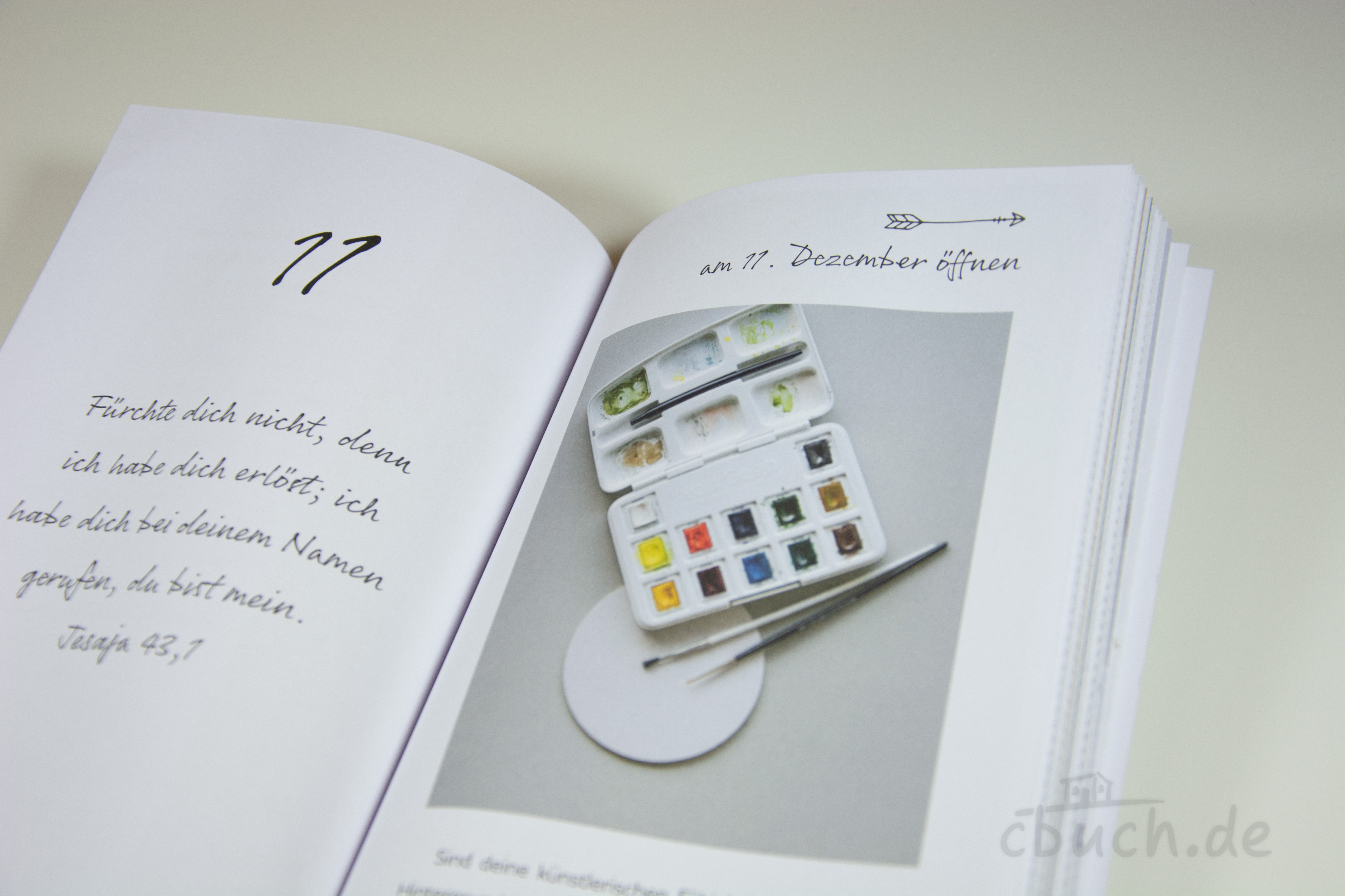 Wasserfarben-Set mit Pinseln auf Seite eines geöffneten Buch