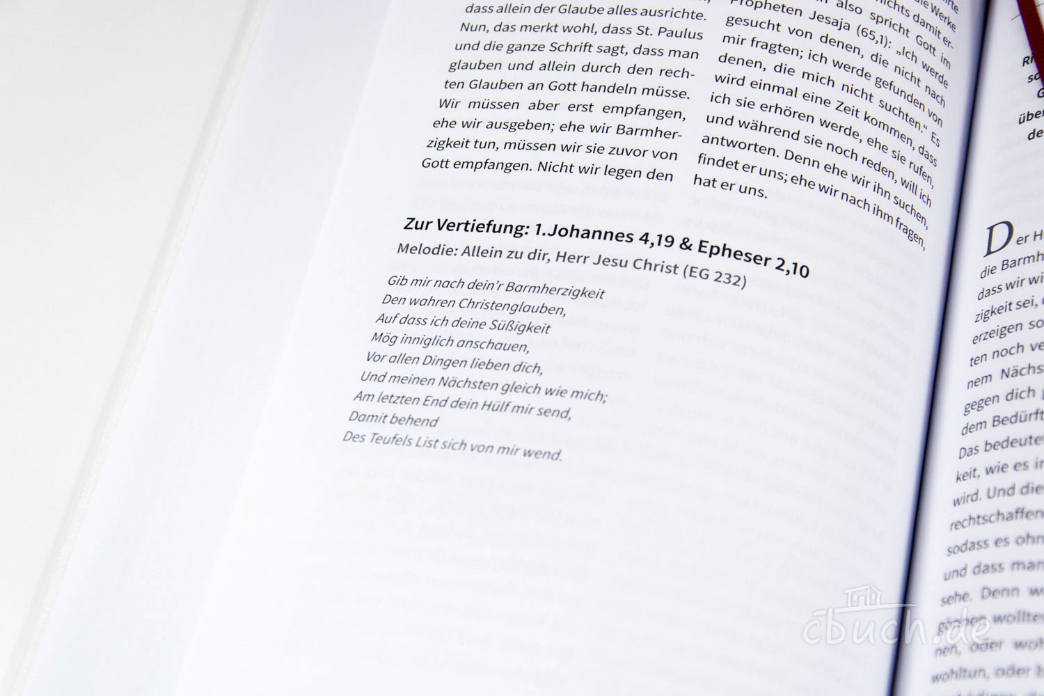 Geöffnete Buchseite mit Bibelversen und Liedtext Detailaufnahme von Buchseite mit 1. Johannes 4,19 und Ephese