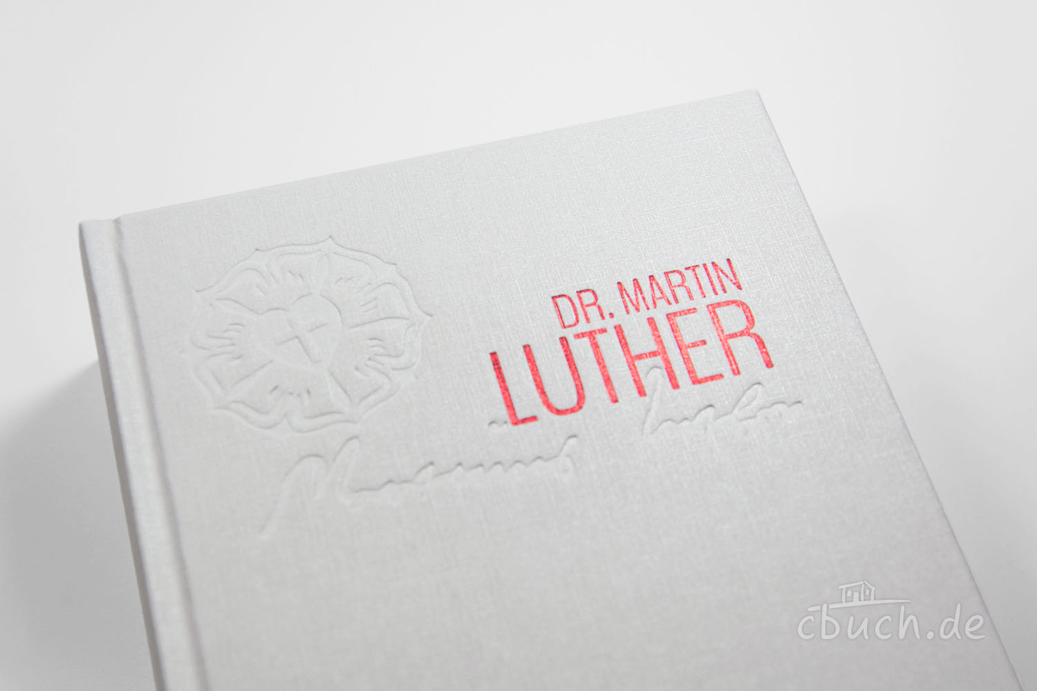 Weißes Buch mit Prägung und rotem Dr. Martin Luther Schriftz Nahaufnahme von weißem Buch mit Dr. Martin Luther Schriftzug
