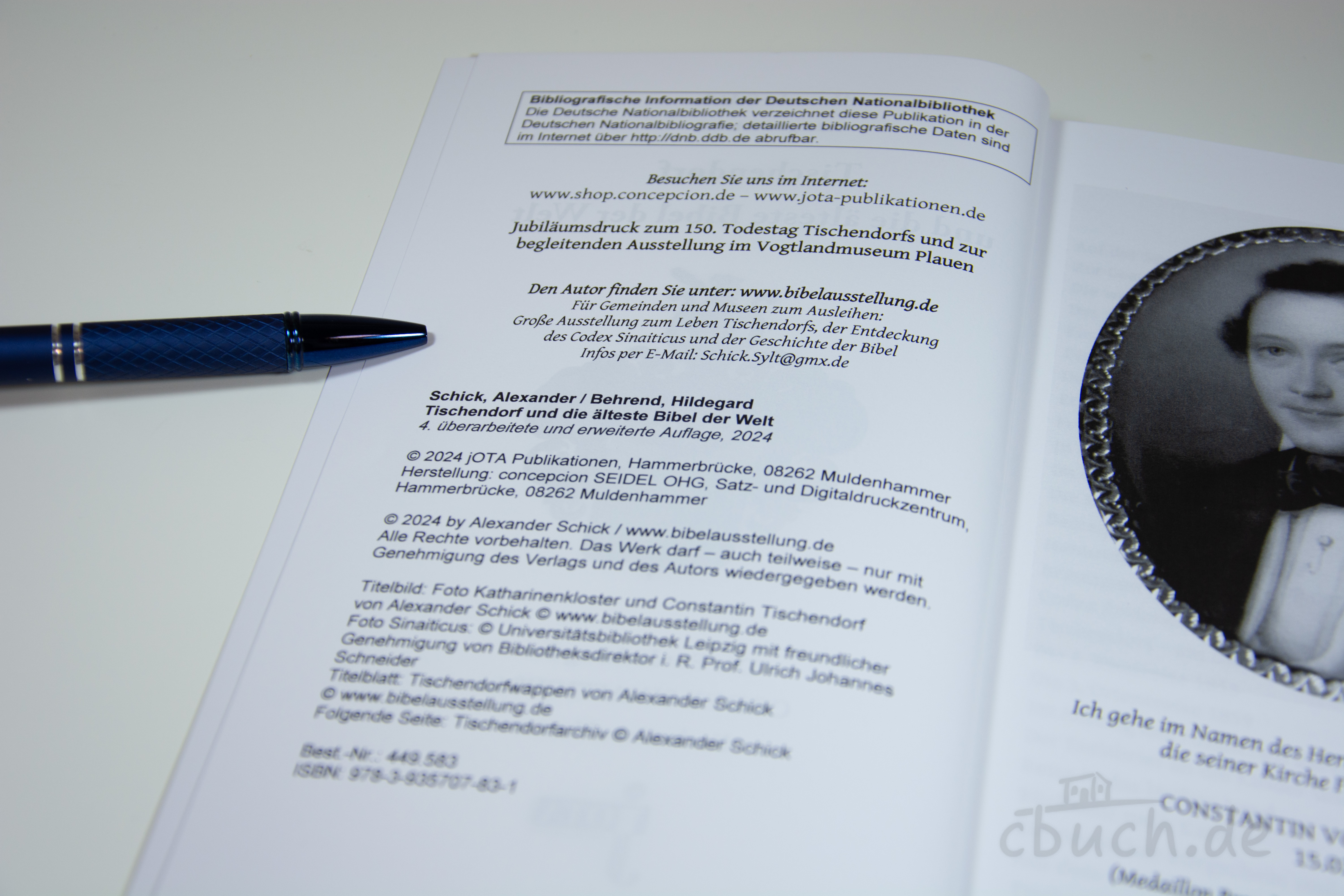 Aufgeschlagene Buchseite mit Bibliografie und Portrait Buchseite mit Text und Foto, daneben ein blauer Kugelschreib