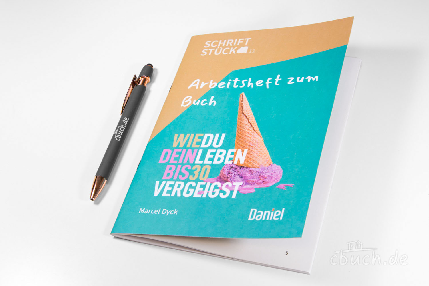 Arbeitsheft zum Buch 'Wie du dein Leben bis 30 vergeigst' Arbeitsheft mit Eiscreme-Motiv und Stift auf weißem Untergru