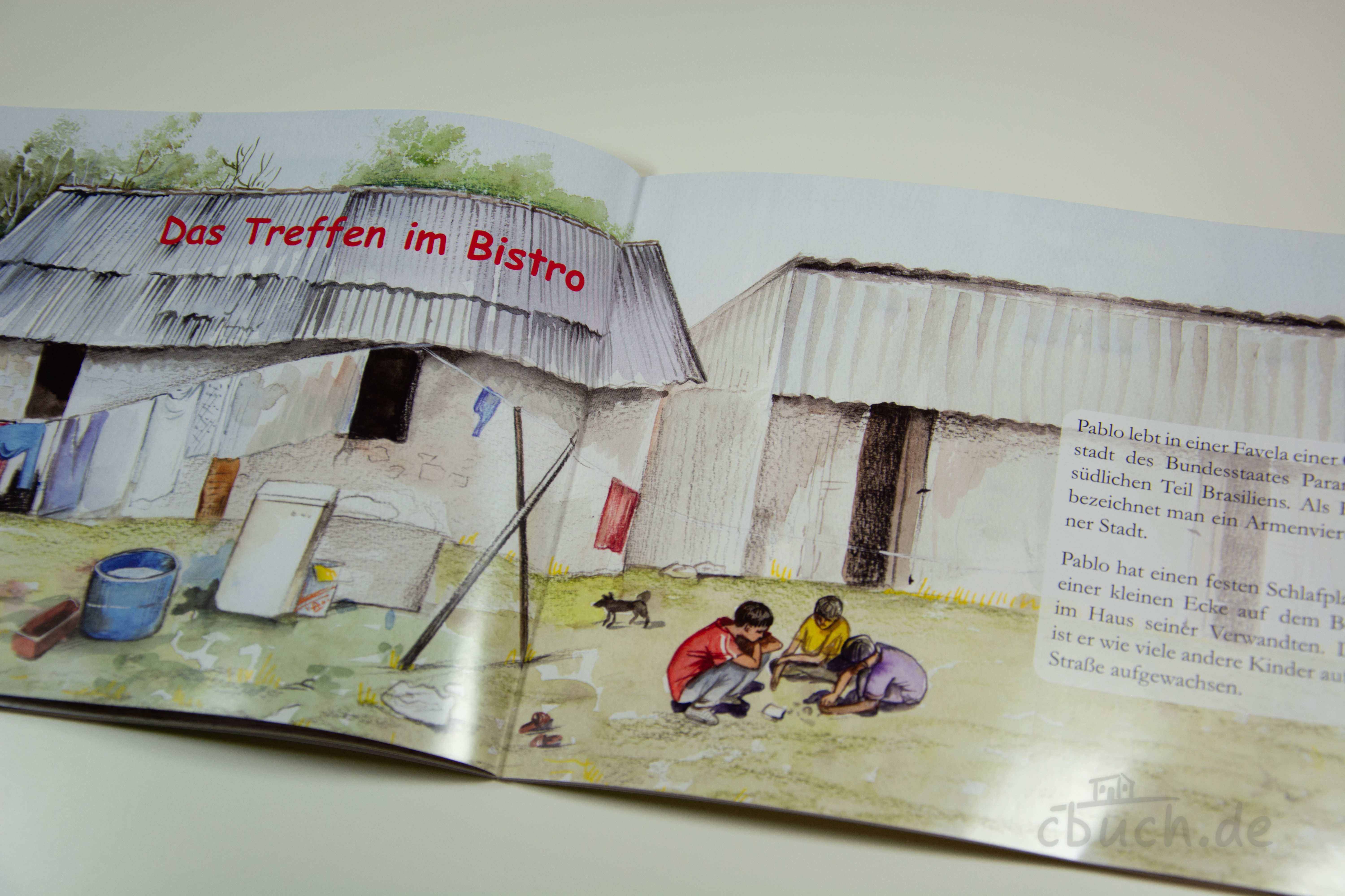 Das Treffen im Bistro - Kinder in Brasilien (Heft 6) | Samenkorn Aufgeschlagenes Kinderheft „Das Treffen im Bistro - Kinder in Brasilien (Heft 6)“ von Samenkorn mit farbiger Illustration einer Favela in Brasilien und spielenden Kindern.
