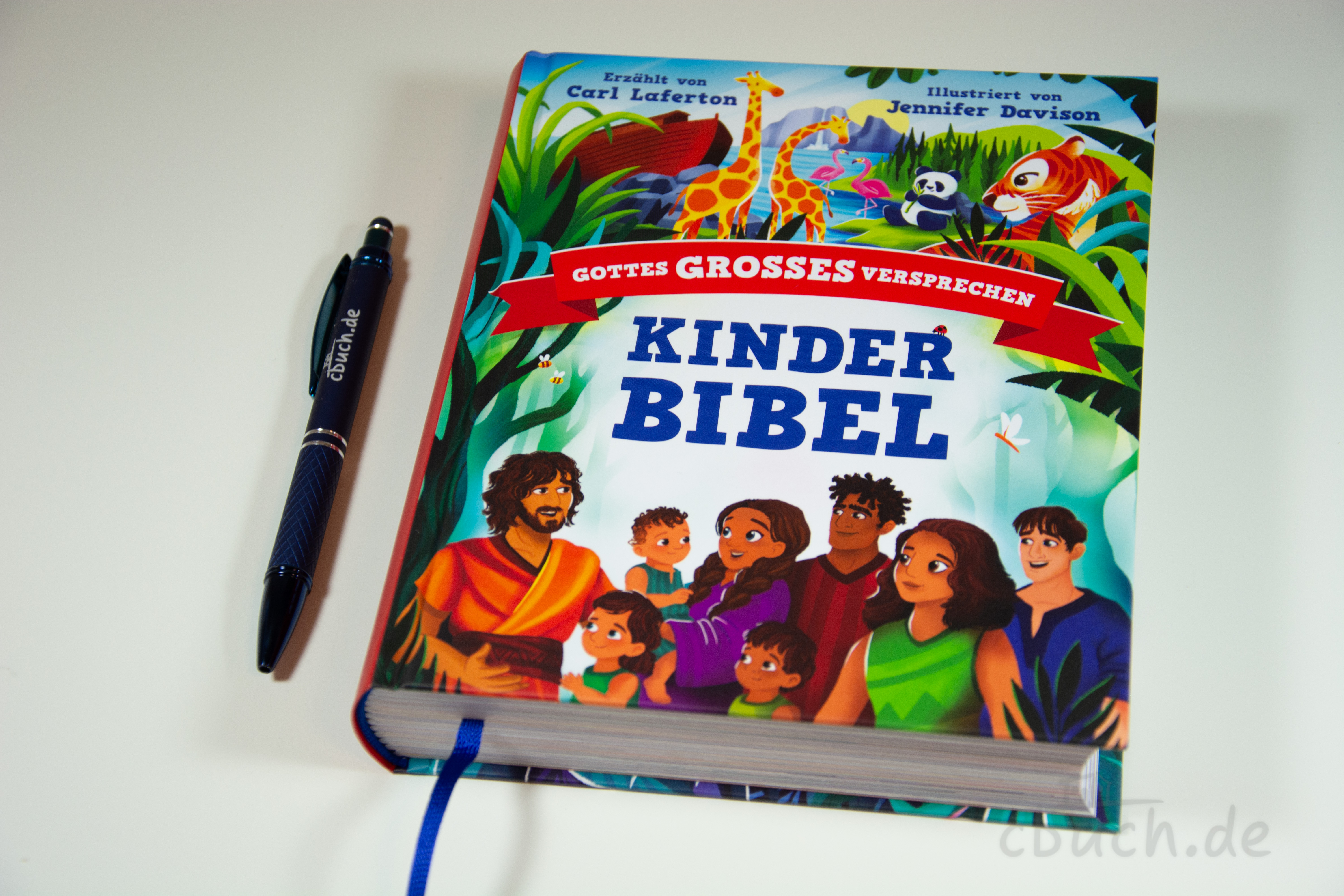 Buch Kinderbibel mit bunten Bildern und Figuren neben Stift